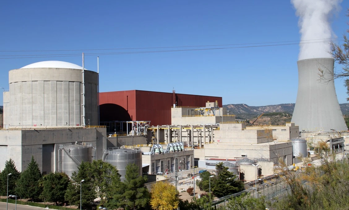 Instalaciones de una central nuclear con edificio de contención, torre de refrigeración y edificios industriales.