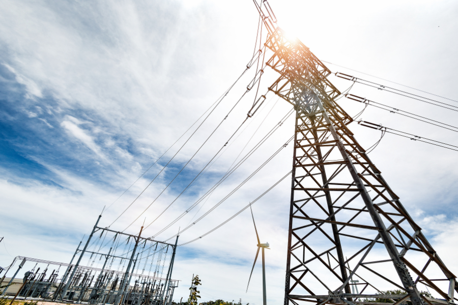 Torre de alta tensión y subestación eléctrica conectadas a la red de transporte de electricidad.
