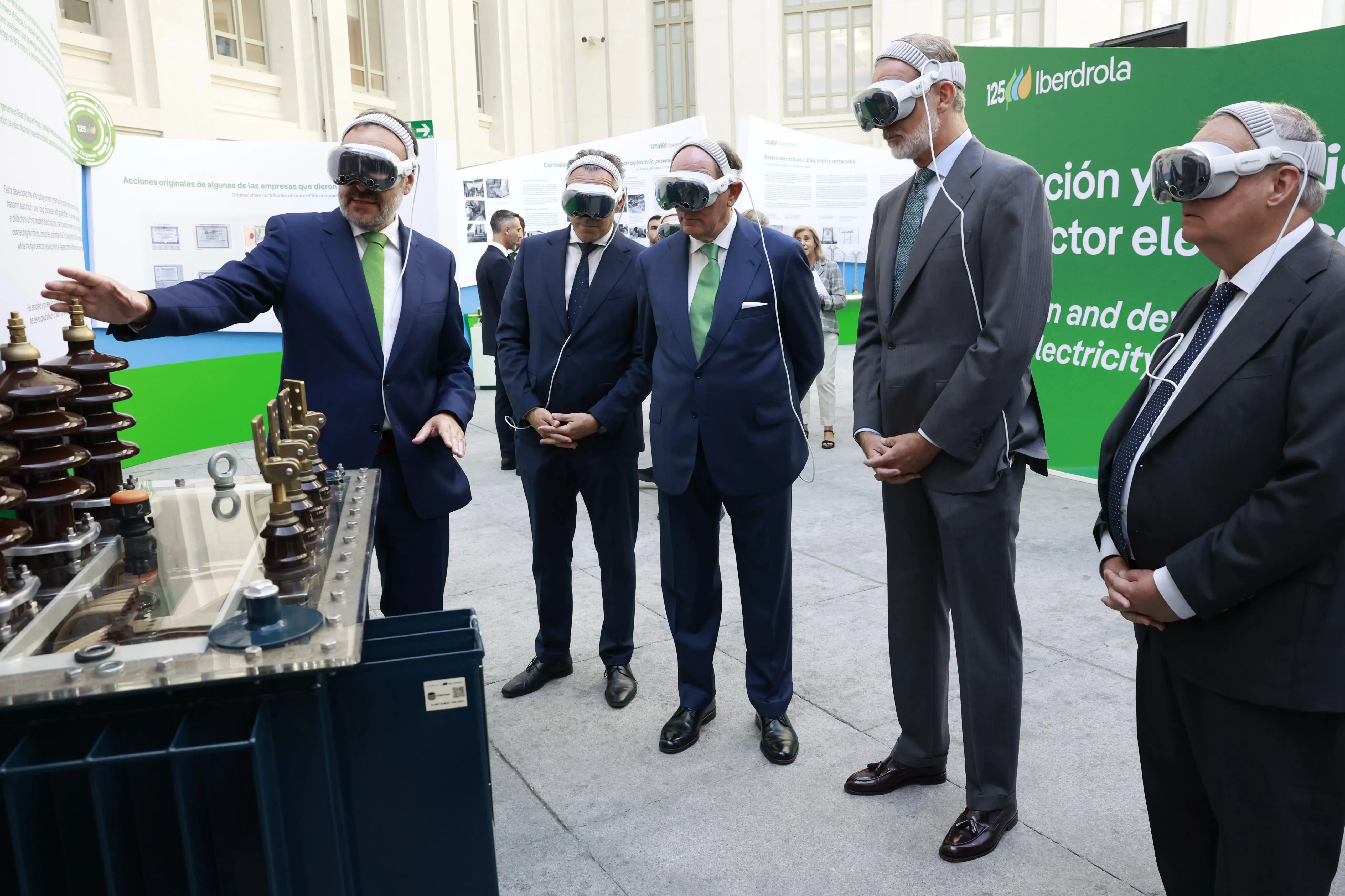 King Felipe VI, Ignacio Galán, and other representatives wear virtual reality headsets while observing an Iberdrola electrical installation.