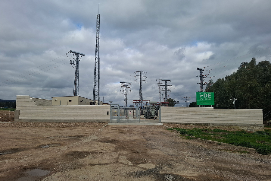 Subestación eléctrica con equipos de alta tensión, vallado perimetral y torres de líneas eléctricas bajo cielo nublado.
