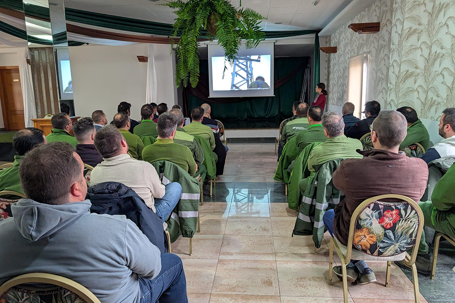 Grupo de profesionales sentados en una sala durante una presentación técnica con proyección sobre infraestructura eléctrica.