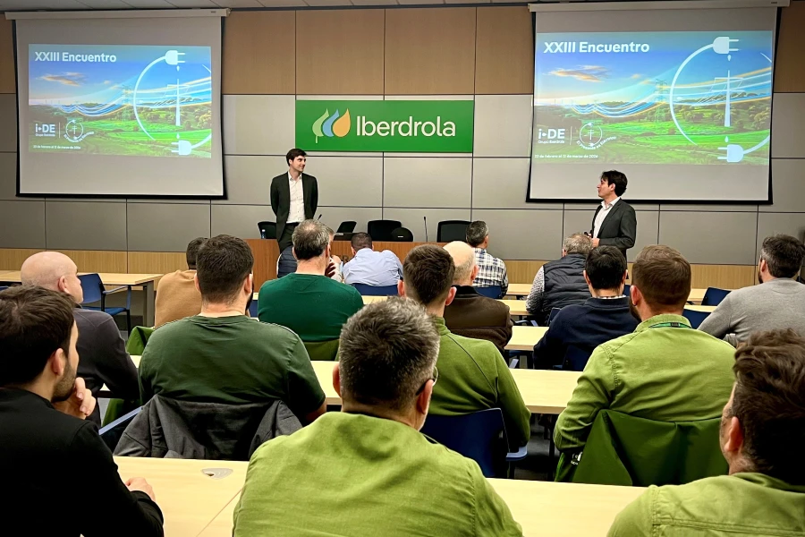 Presentación corporativa en sala de formación de Iberdrola ante empleados, con diapositivas sobre encuentro energético.