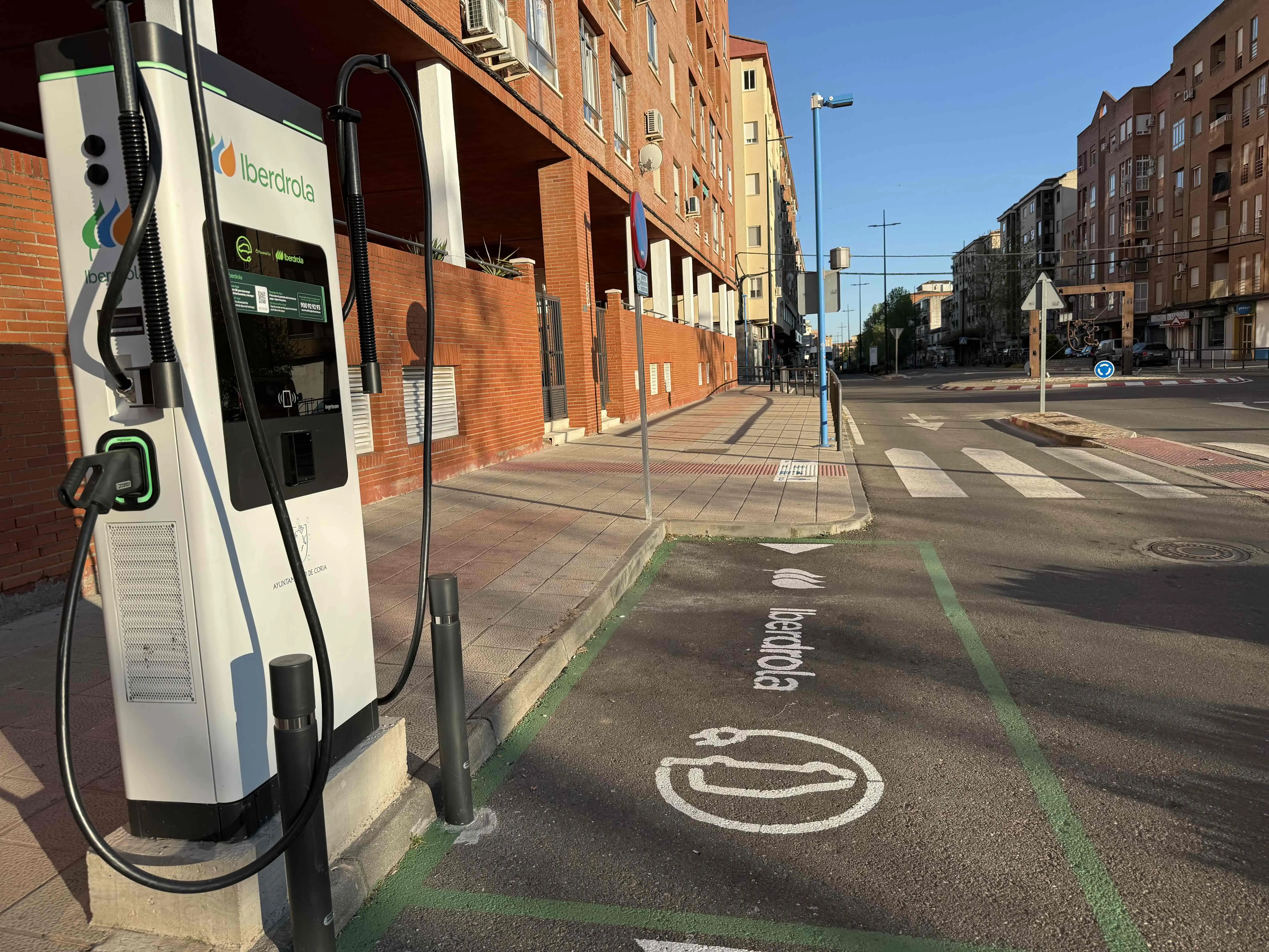 Estación de carga para vehículos eléctricos de Iberdrola en la vía pública, con un carril marcado para la carga.