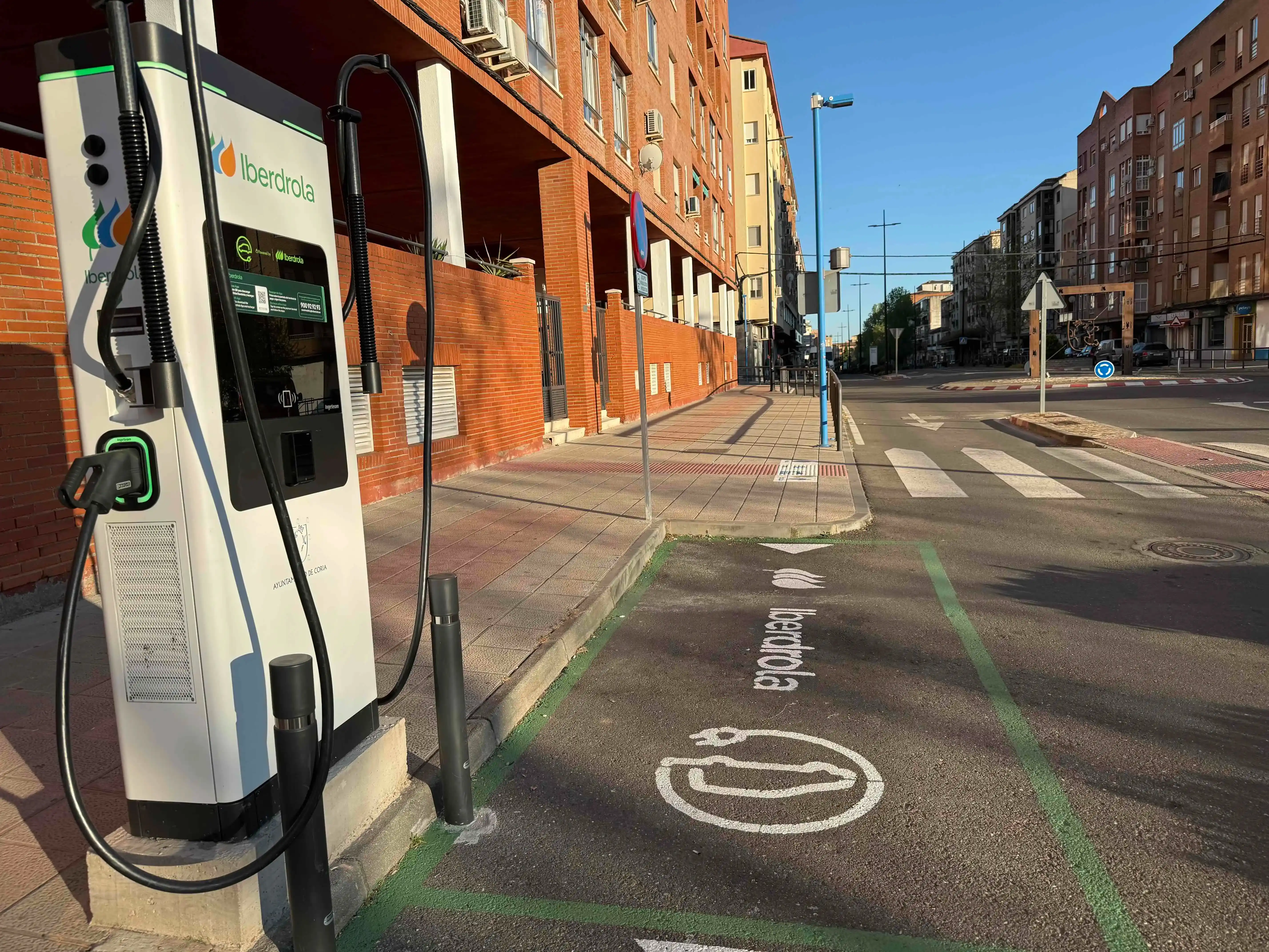 Iberdrola electric vehicle charging station on the street, with a marked lane for charging.