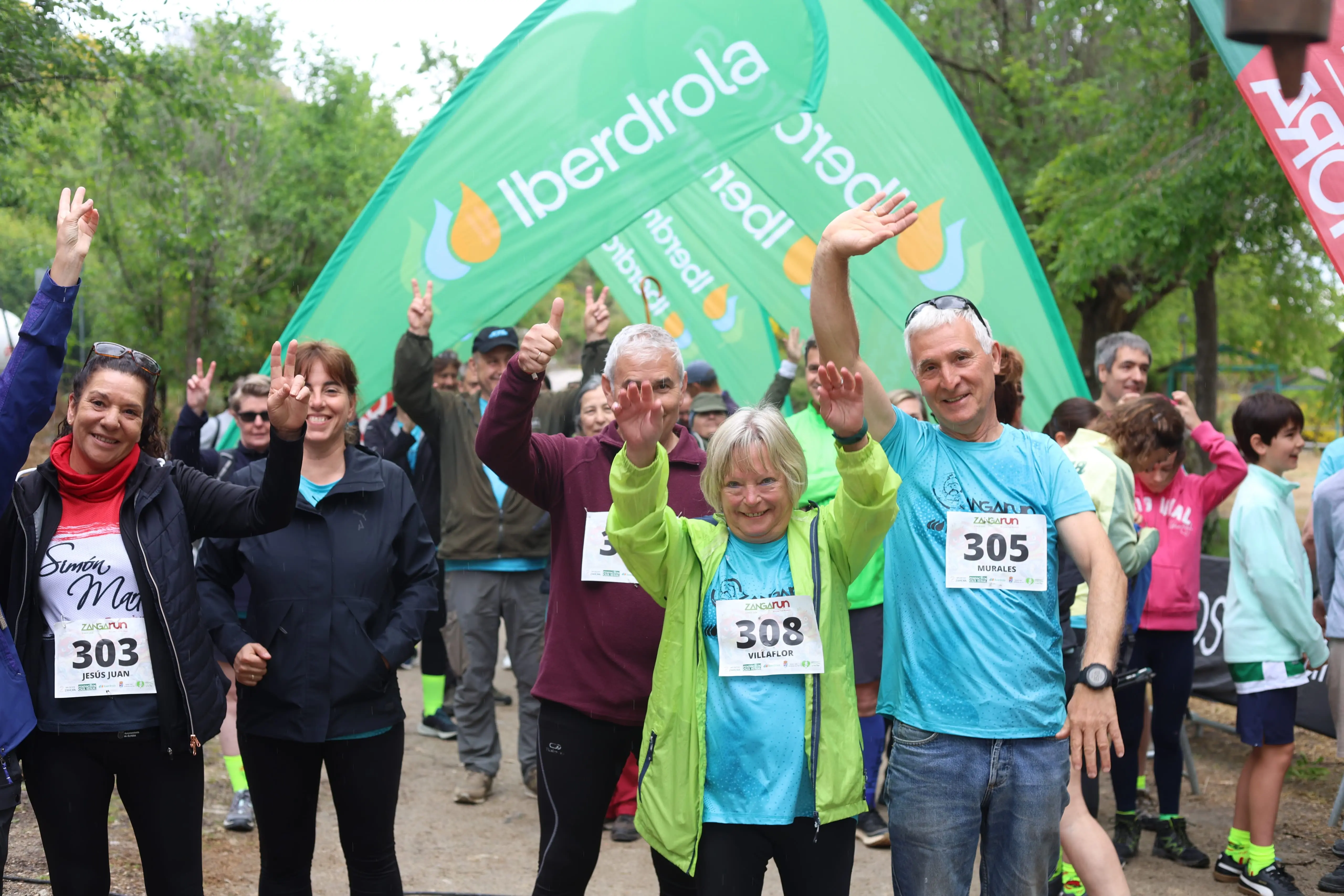 Participants in a fun run wave under Iberdrola arch in a natural setting