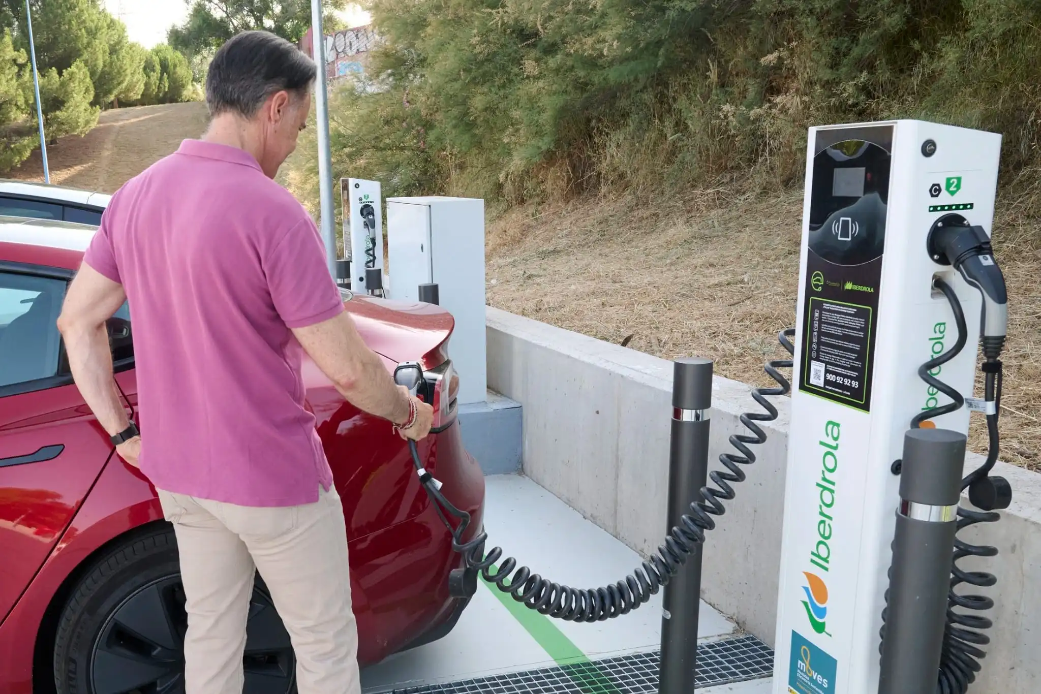 Persona cargando su coche eléctrico en un punto de carga de Iberdrola.
