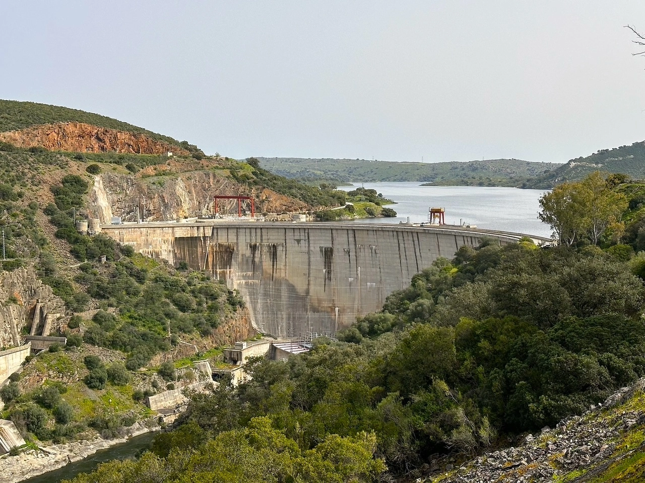 Vista panorámica de la presa de Valdecañas, con su estructura imponente sobre un paisaje montañoso.