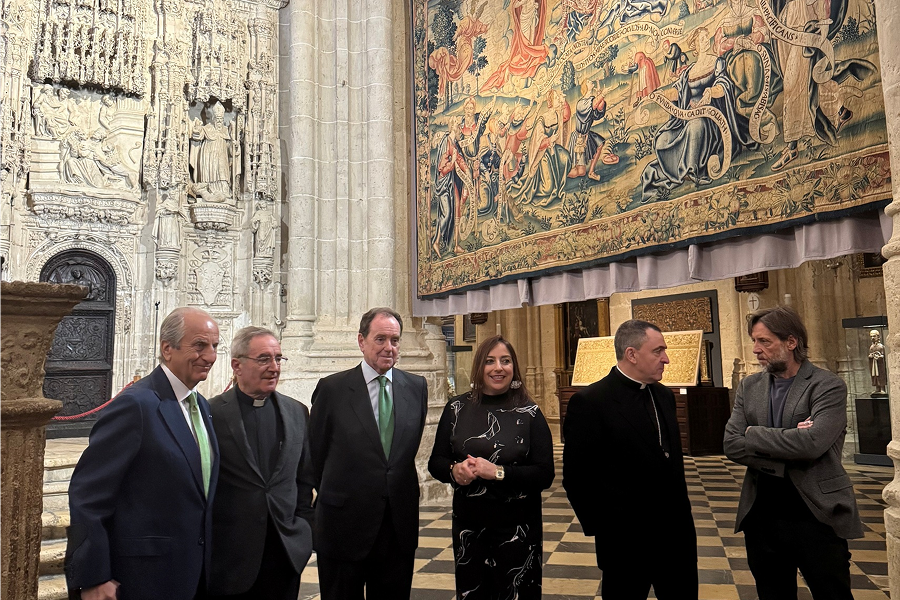 Representantes de Iberdrola durante una visita a la Catedral de Palencia, destacando una tapicería histórica en el fondo.