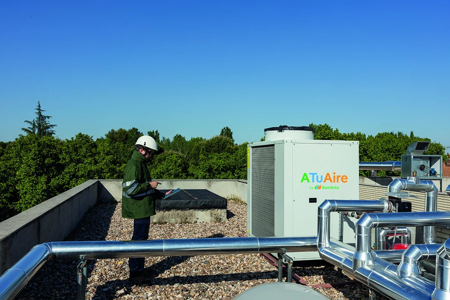 Técnico revisa una unidad de aerotermia ATUaire de Iberdrola en una azotea.