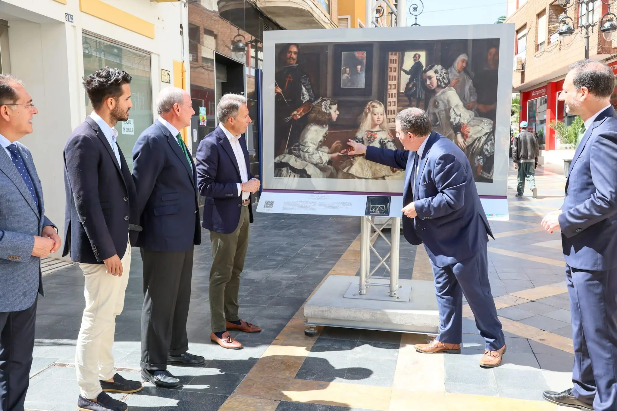 Group of people viewing a reproduction of Velázquez’s “Las Meninas” in an outdoor exhibition in Lorca.