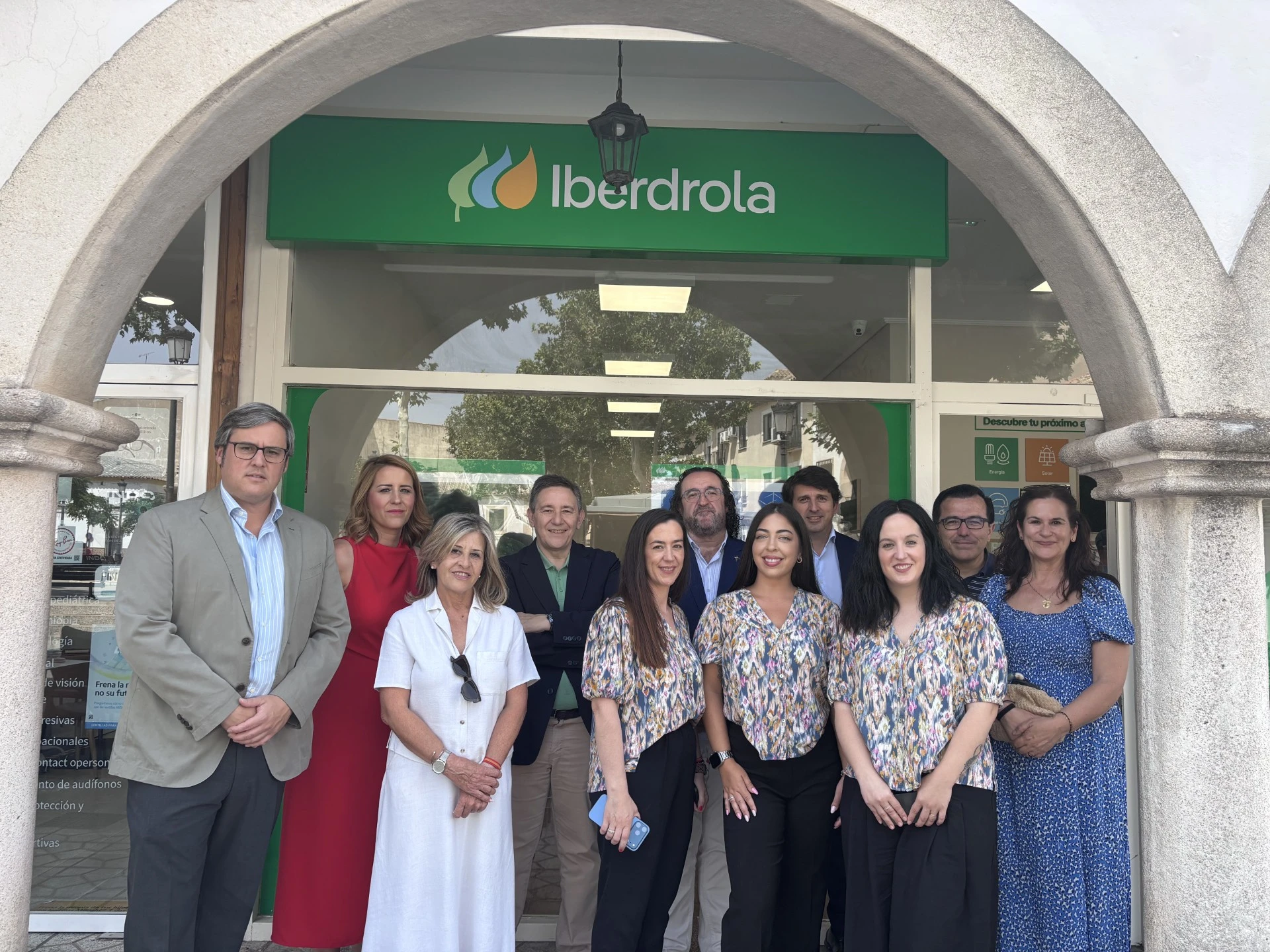 Grupo de personas frente a una oficina de Iberdrola con acceso de atención al cliente.