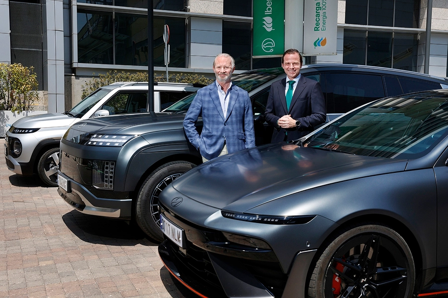 Luis Buil and Leopoldo Satrústegui pose beside Hyundai electric vehicles