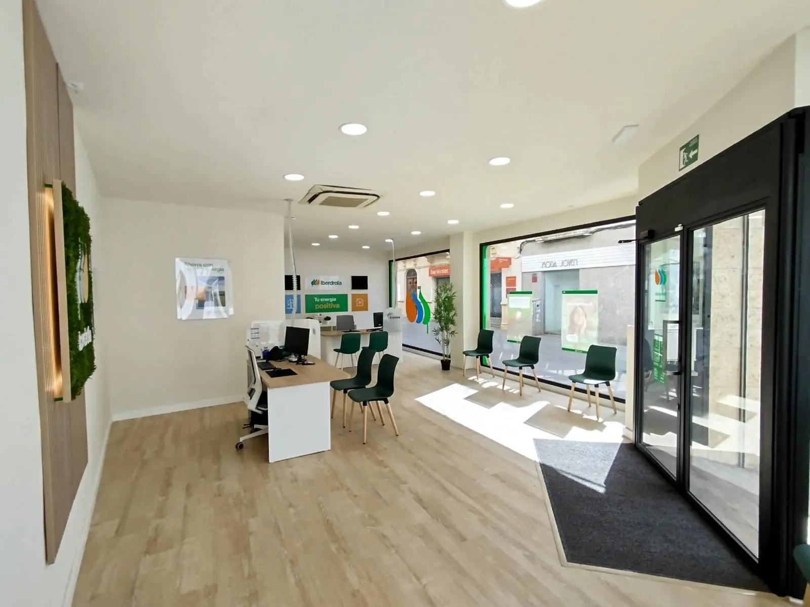 Interior de una oficina de atención al cliente de Iberdrola con mostradores y zona de espera.