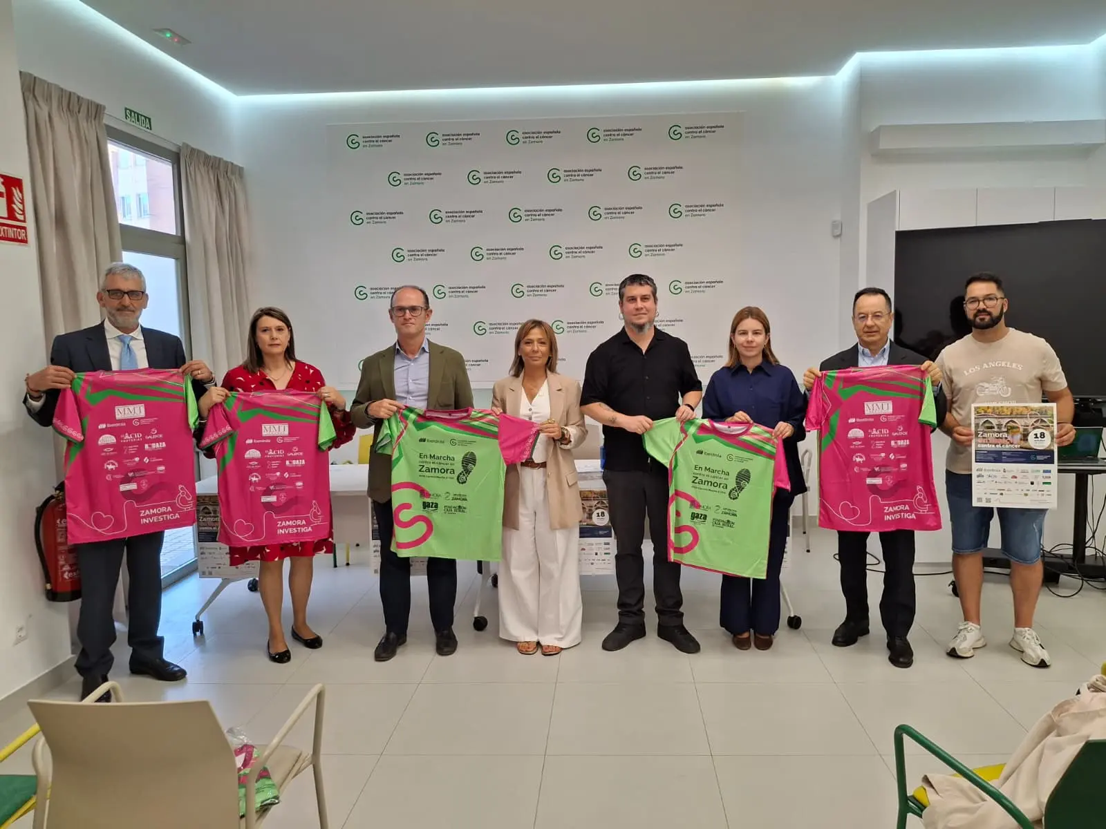 Representatives present shirts for a charity cancer awareness race in Zamora