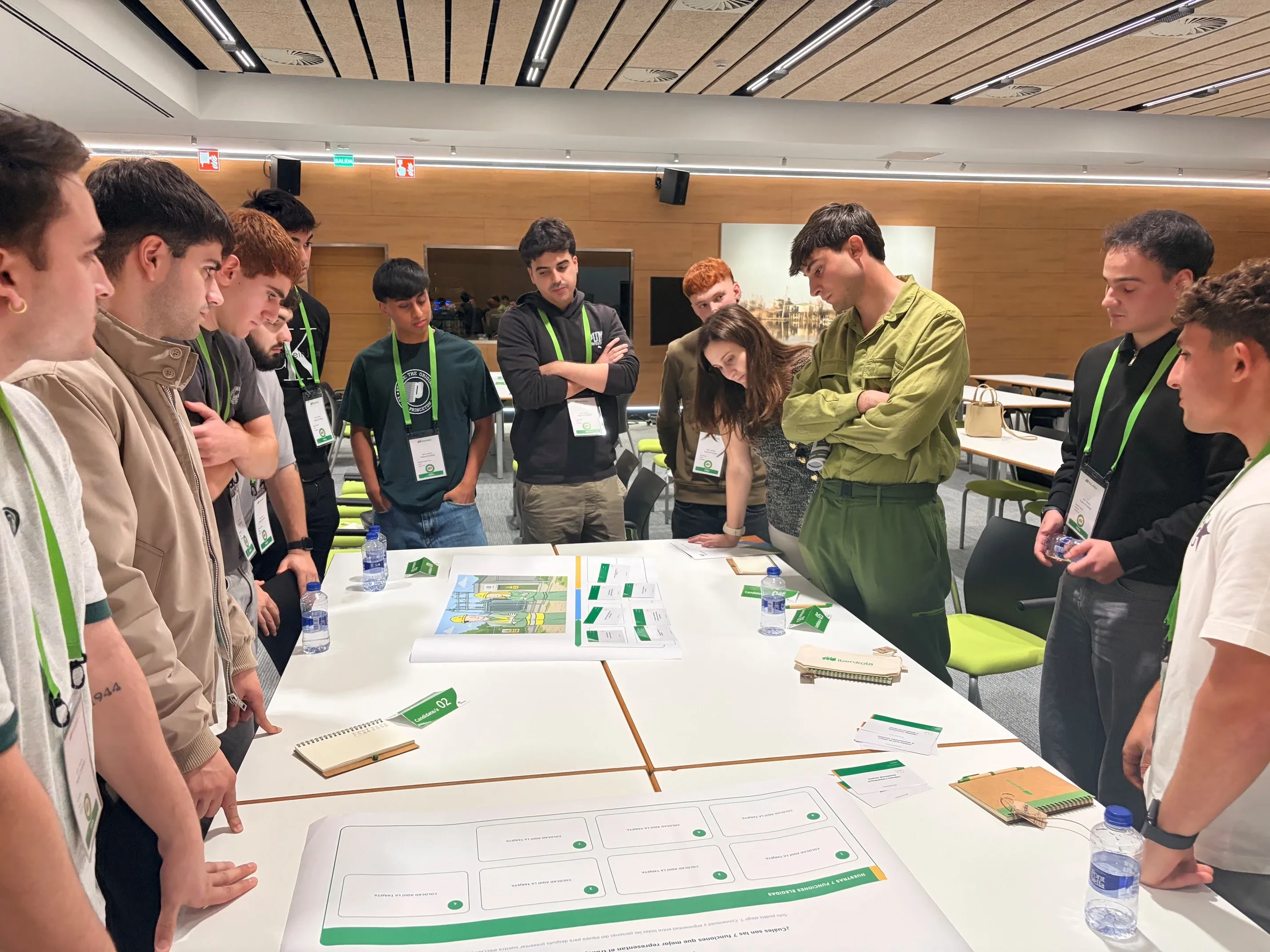 Jóvenes participantes en un taller de Iberdrola analizan materiales y propuestas alrededor de una mesa.