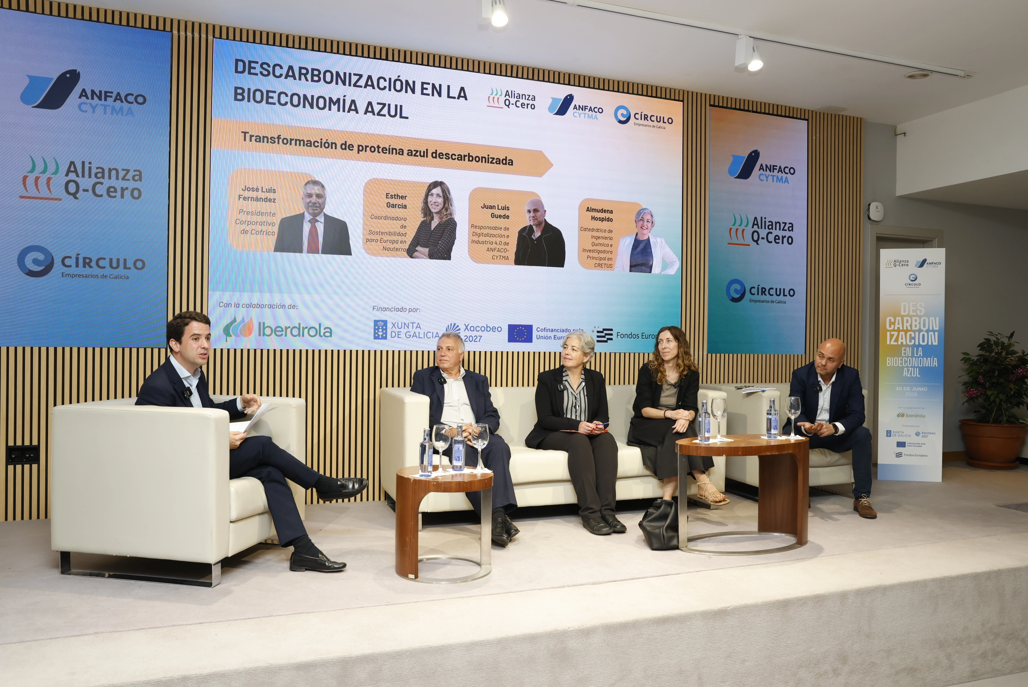 Panel discussion at event on decarbonization in blue bioeconomy with speakers and moderator on stage.