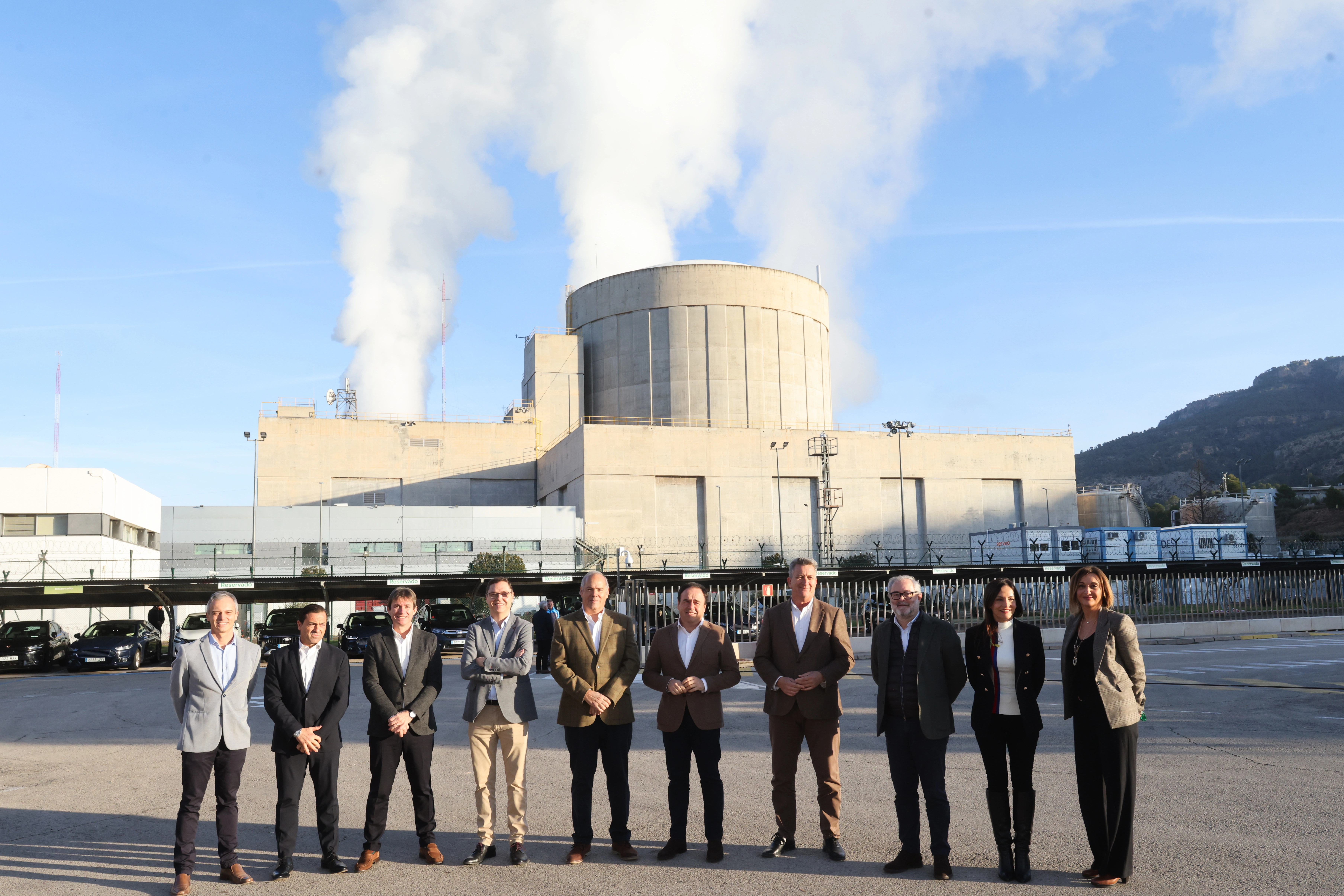 The President of the Valencian Government, Juanfran Pérez Llorca, accompanied by Mario Ruiz-Tagle, CEO of Iberdrola Spain, and Julio Castro, CEO of Iberdrola Sustainable Energy Spain, along with other team members, pose in front of a power plant.