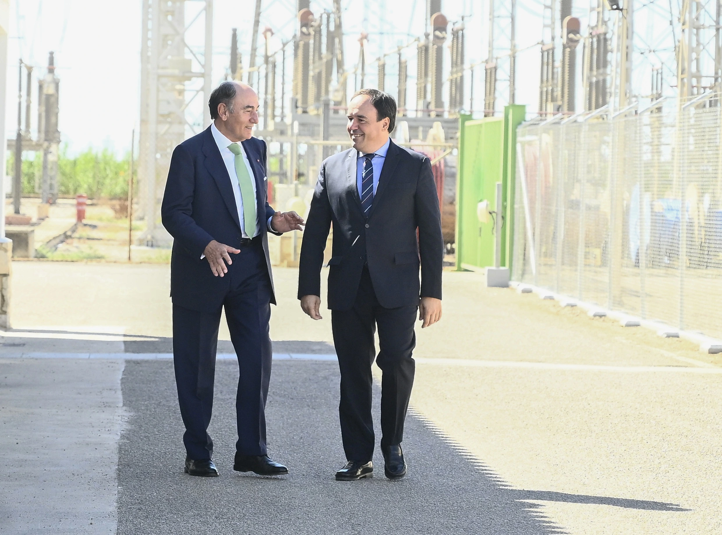 Ignacio Galán, presidente ejecutivo de Iberdrola, y Juanfran Pérez Llorca, president de la Generalitat Valenciana, conversan durante una visita a una instalación eléctrica con equipos de subestación al fondo.