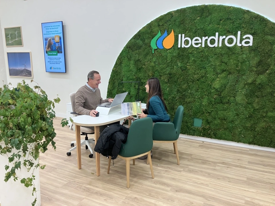 Persona asesorando sobre soluciones energéticas en un espacio de atención al cliente de Iberdrola.