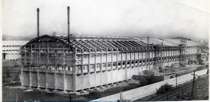 Historic exterior view of a Nitrastur industrial building during the construction of its roof.