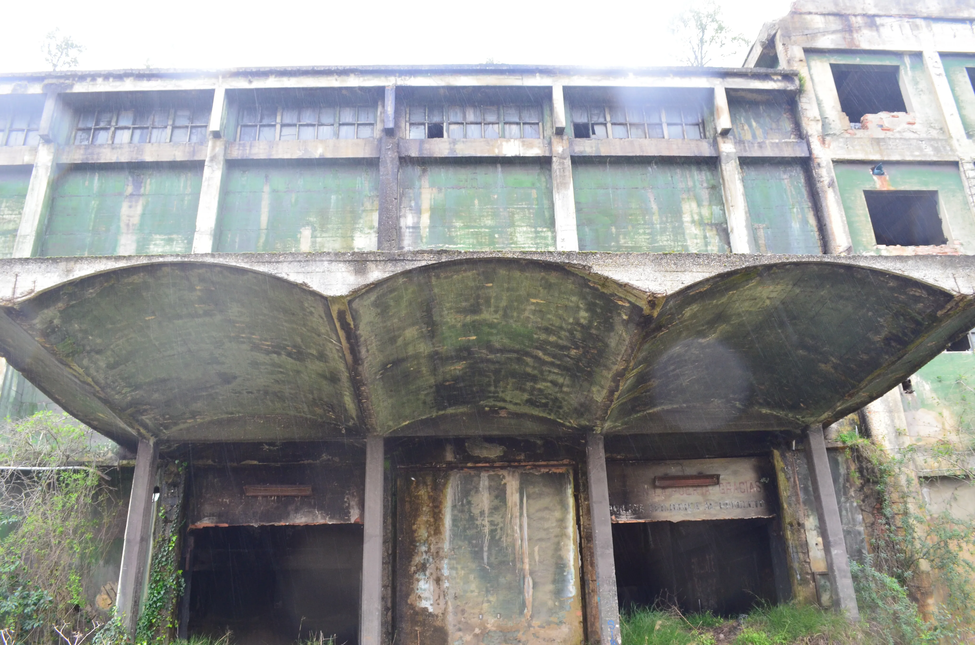 Current condition of a Nitrastur industrial building façade with a deteriorated concrete canopy.
