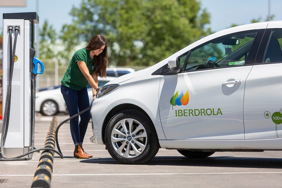 Persona cargando un vehículo eléctrico en un punto de recarga.